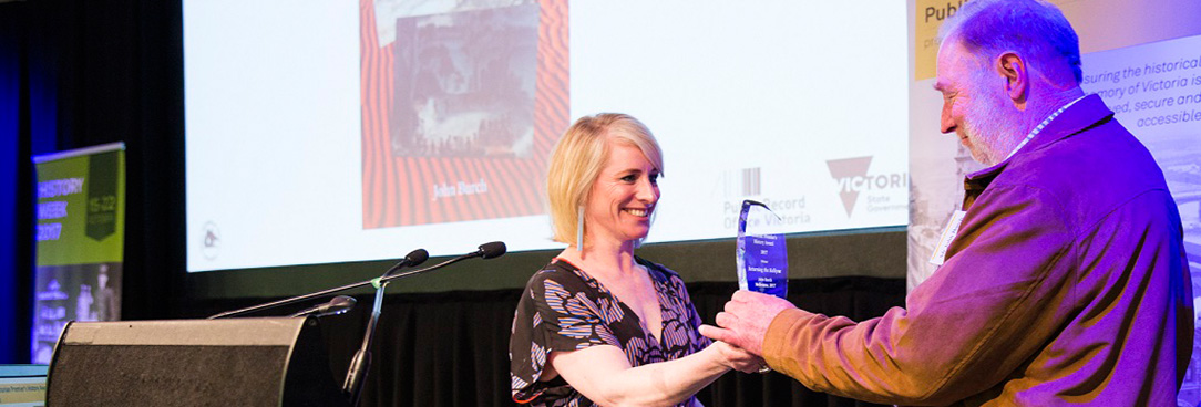 John Burch accepts award from Catherine Andrews 